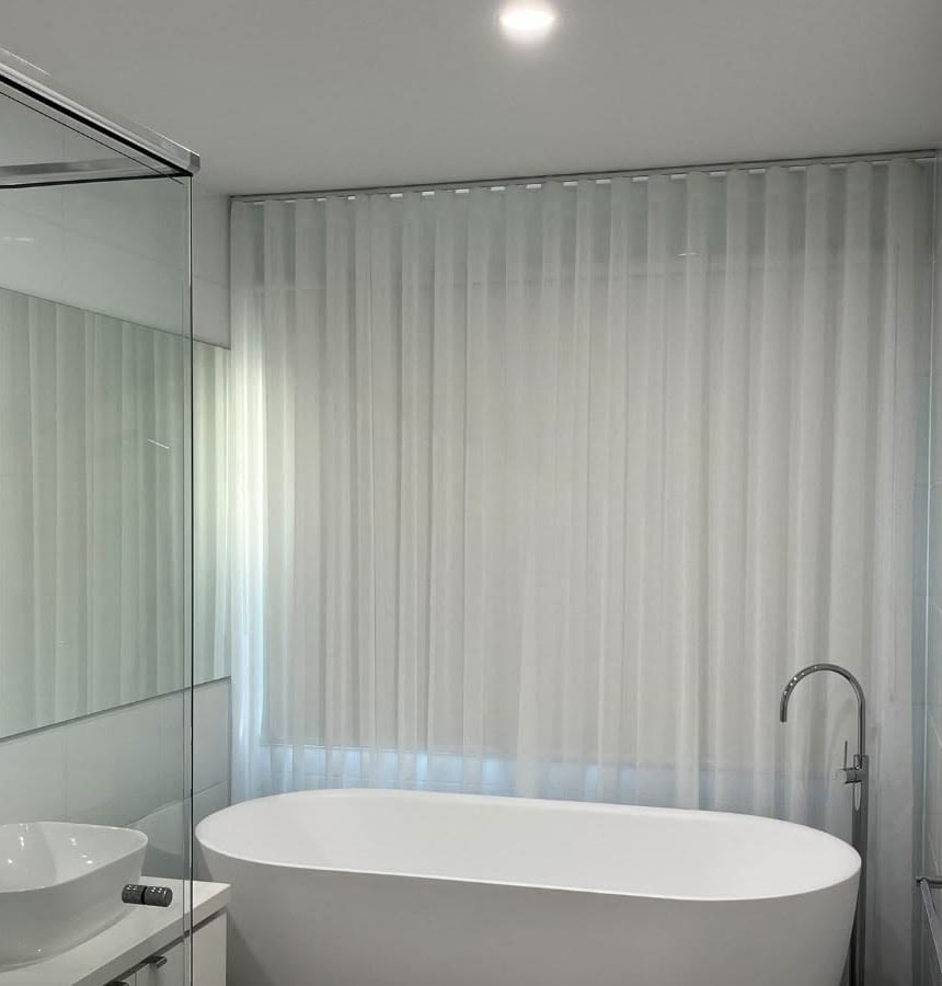 Sheer curtains beside a freestanding bath