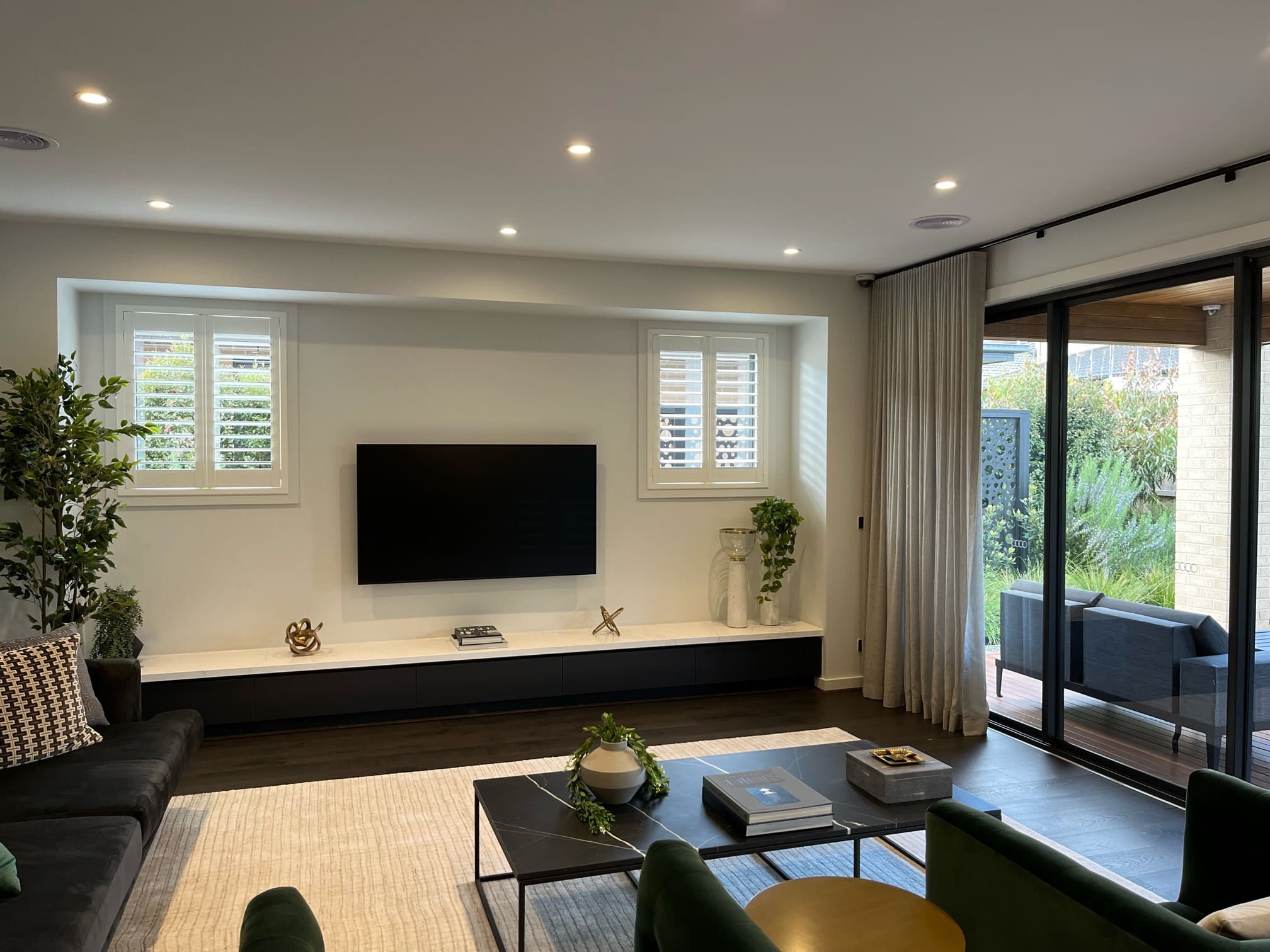 Plantation shutters flanking a living-room media wall