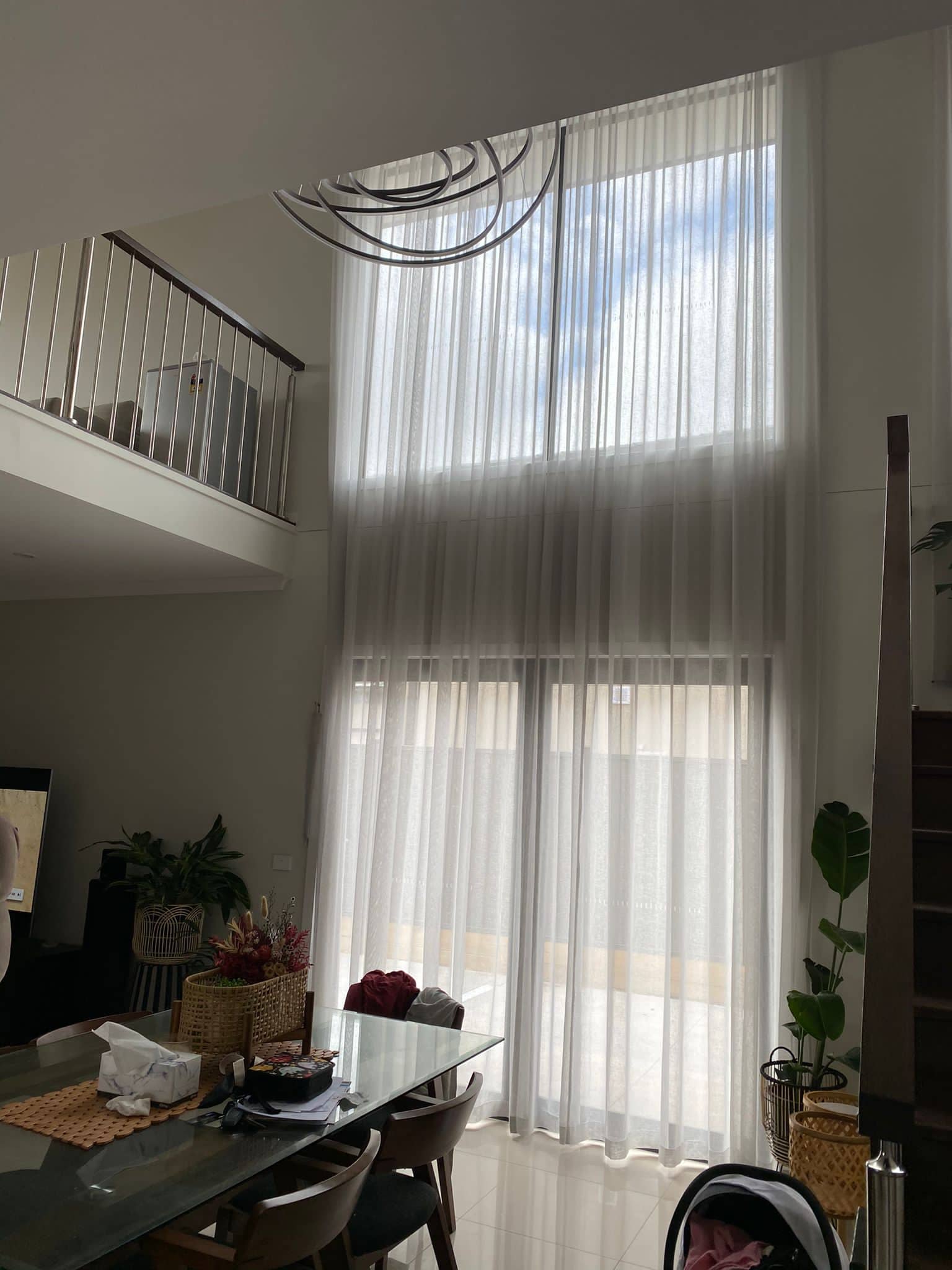 Full-height sheer curtains in a double-storey void